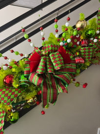 Luxe ribbons, festive sprays adorn this staircase garland designed by Juniper and Gold.  
