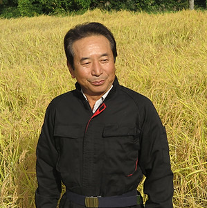 稲刈り間近の棚田でインタビューを受ける片桐一さん