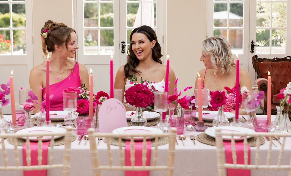 Bride laughs with bridesmaids at stylish pink set up wedding table during reception. High end wedding at Elmhay Park Somerset