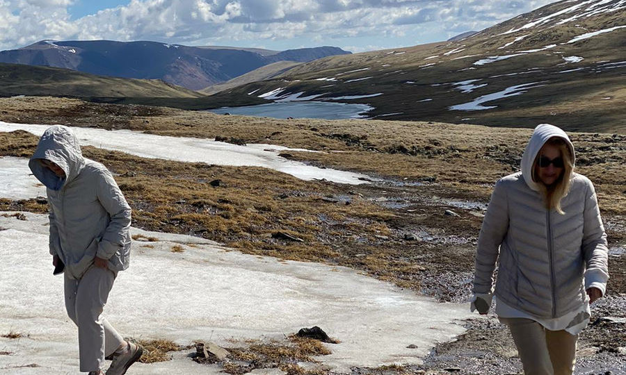 Two women travellers hiking beside a frozen lake in the Altai Mountains