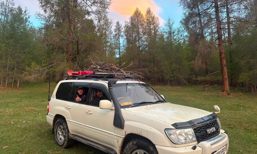 4WD vehicle with a roof rack parked in a forest in Bayan-Ölgii