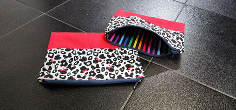 a pencil case with a leopard print lined with rainbow stripes