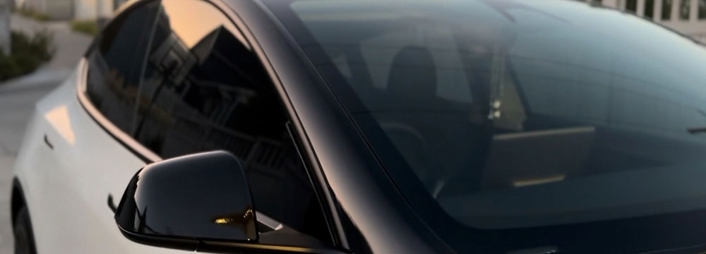 White Tesla Model 3 Custom Vinyl Wraps, gloss black "Cockpit" wrap plus gloss black mirror cap wrap parked on a suburban street Drip Autosalon.