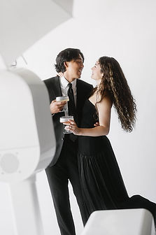 Couple in elegant attire toasting at photo booth