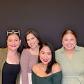 Four smiling women pose for a photo with a black background Captured Celebrations