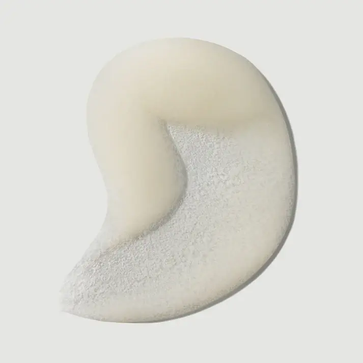 Thumbnail: Close-up of a white creamy scrub texture containing small, uniform exfoliating beads.