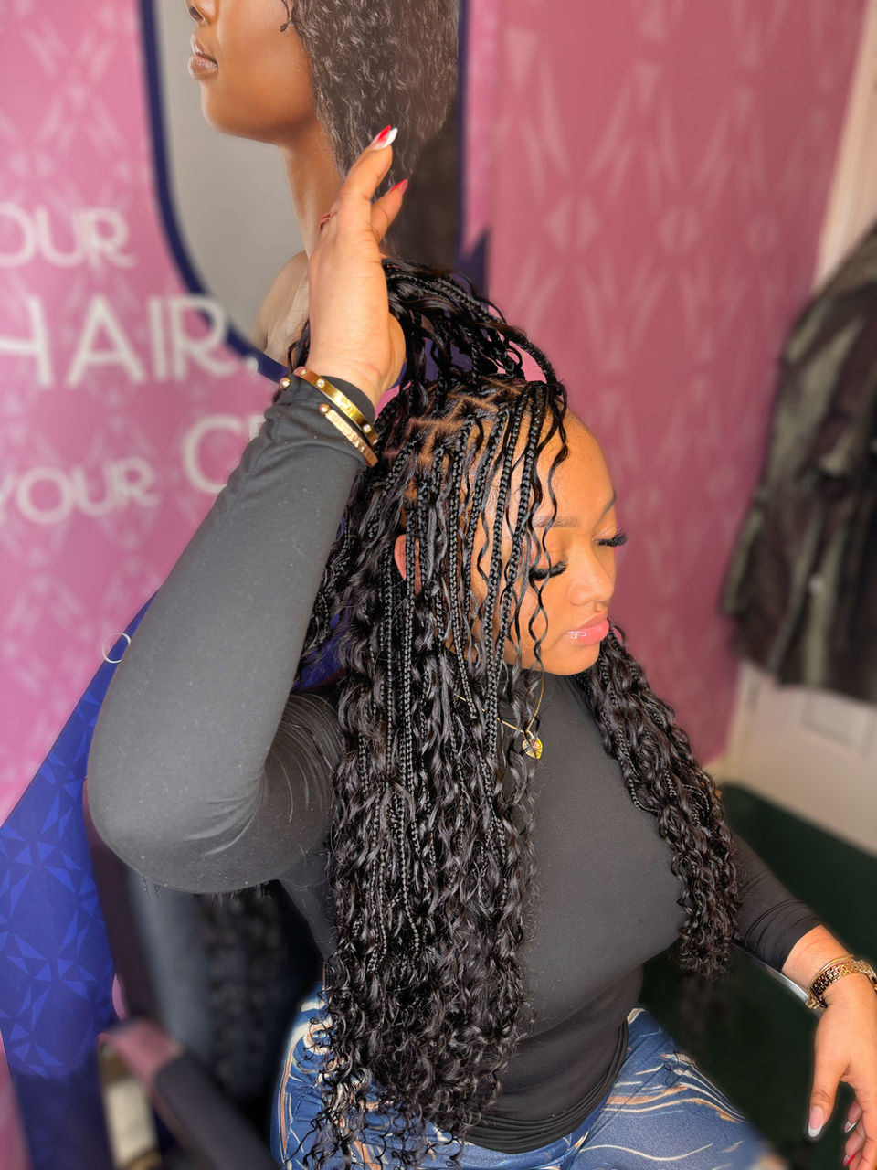 Client with long, black, small boho braids which are waist length styled by Bella Avanti