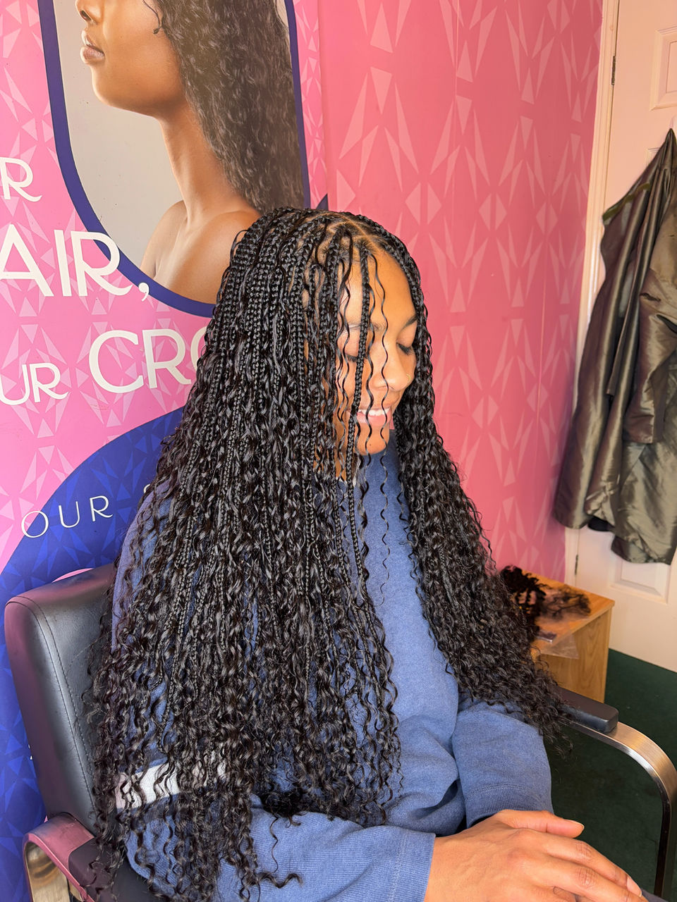 Client with long black boho braids which are waist length styled by Bella Avanti