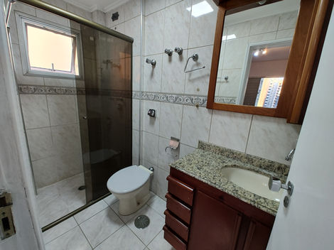 Banheiro com mobília básica, incluindo pia, vaso sanitário e espelho.