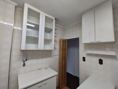 Cozinha com mobília básica e acabamento neutro, equipada com pia, armários