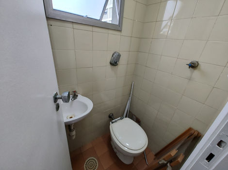 Banheiro com mobília básica, incluindo pia, vaso sanitário e espelho.