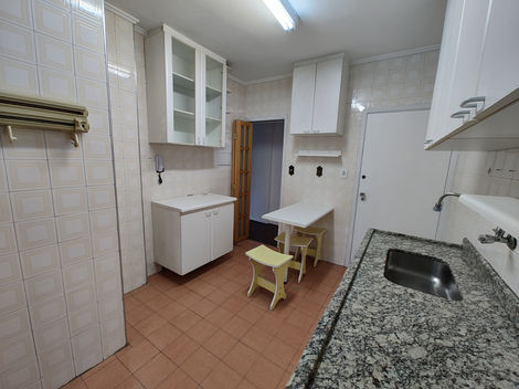 Cozinha com mobília básica e acabamento neutro, equipada com pia, armários