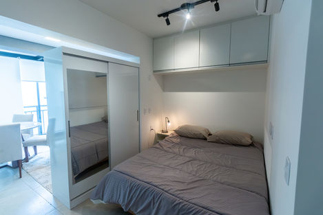 "Área social integrada do studio, com sala, cozinha e jantar em conceito aberto, janelas amplas e iluminação natural destacando o design moderno."