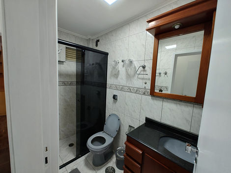 Banheiro com mobília básica, incluindo pia, vaso sanitário e espelho.