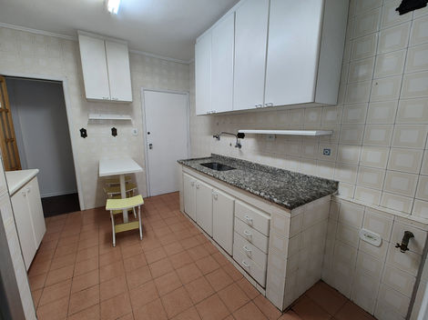Cozinha com mobília básica e acabamento neutro, equipada com pia, armários