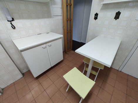 Cozinha com mobília básica e acabamento neutro, equipada com pia, armários