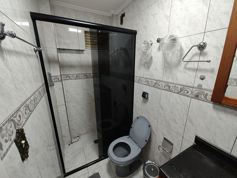 Banheiro com mobília básica, incluindo pia, vaso sanitário e espelho.