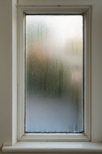 Single pane window in Idaho home showing condensation and heat loss.