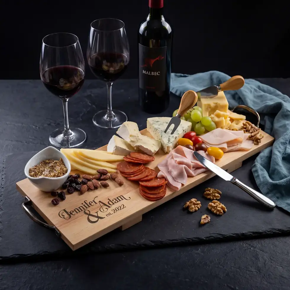 Custom engraved charcuterie board with feet and metal handles featured with Malbec wine and cheese.