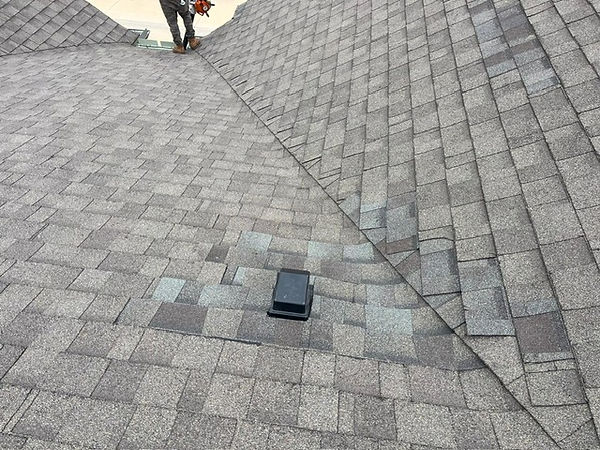 Completed shingle roof repair near ridge and vent