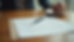 Eye-level view of a handwritten letter on rustic wooden table