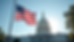 Eye-level view of American flag waving in front of a government building
