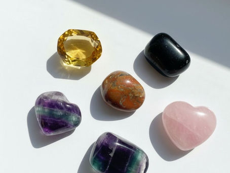 Beyaz zemin üzerinde sergilenen cilalı Sitrin, Oniks, Jasper, Florit ve Pembe Kuvars taşları — küresel değerli taş ticareti ve Tuna Mining’in etik tedarik anlayışını temsil eder.