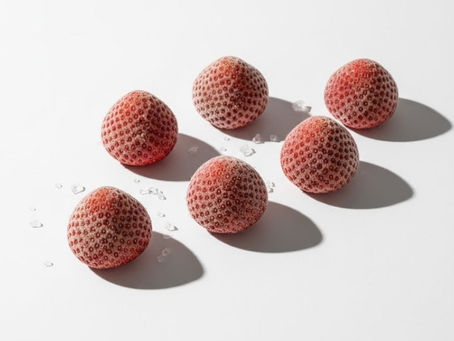 Frozen strawberries on a white place, showcasing their frosty texture and red color.