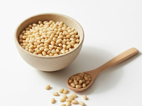 Pine Nuts in a beige ceramic bowl with a wooden spoon – premium bulk Pine Nuts by Tuna Sourcing