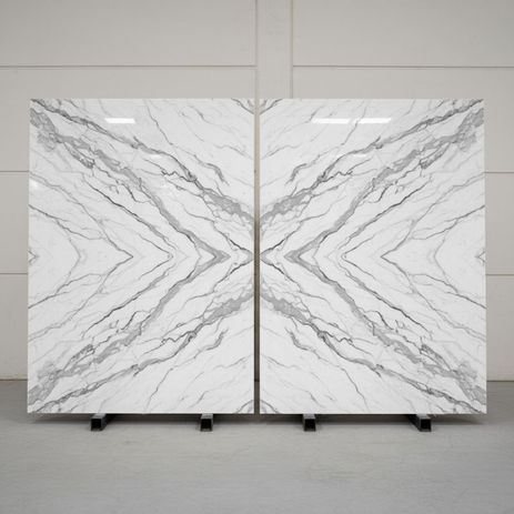 Bookmatched marble slabs on A frames showing continuous veining.