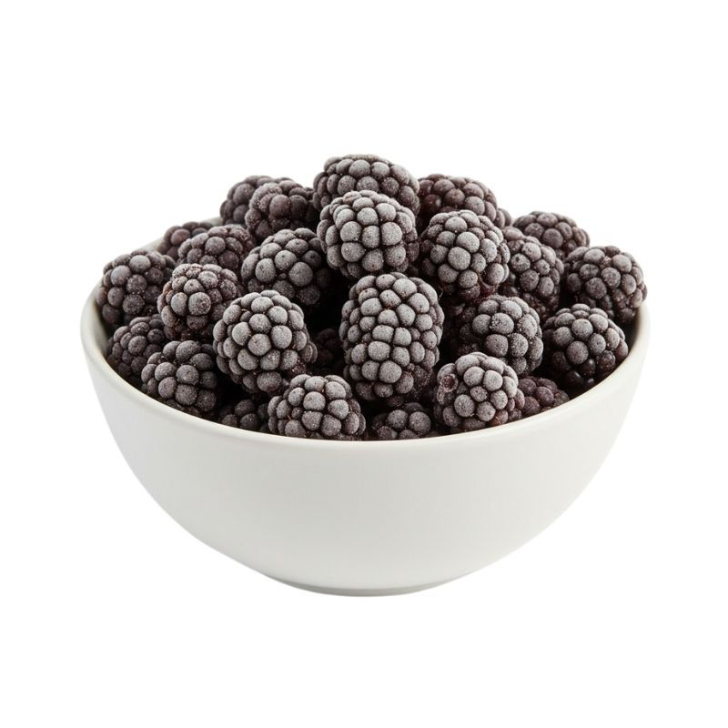 Frozen blackberries in a white ceramic bowl, showing their frosty texture and deep purple color on a bright white background.