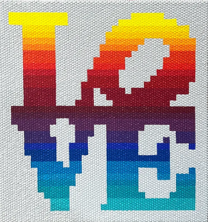 Pixelated letters spelling LOVE in a yellow-to-blue gradient on a bubble wrap canvas.
