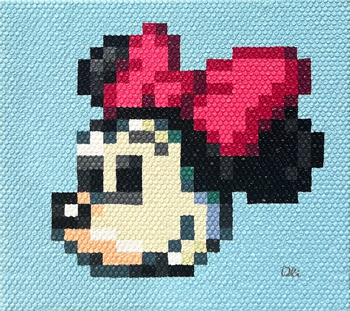 Pixel art of Minnie Mouse with a red bow, painted on light blue bubble wrap.