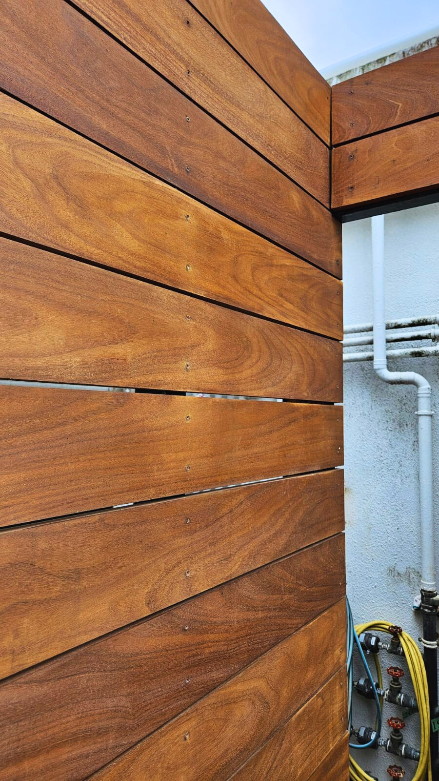 Premium Teak solid wood privacy fence installation for outdoor area, showcasing smooth timber panels and quality craftsmanship in Hong Kong architecture