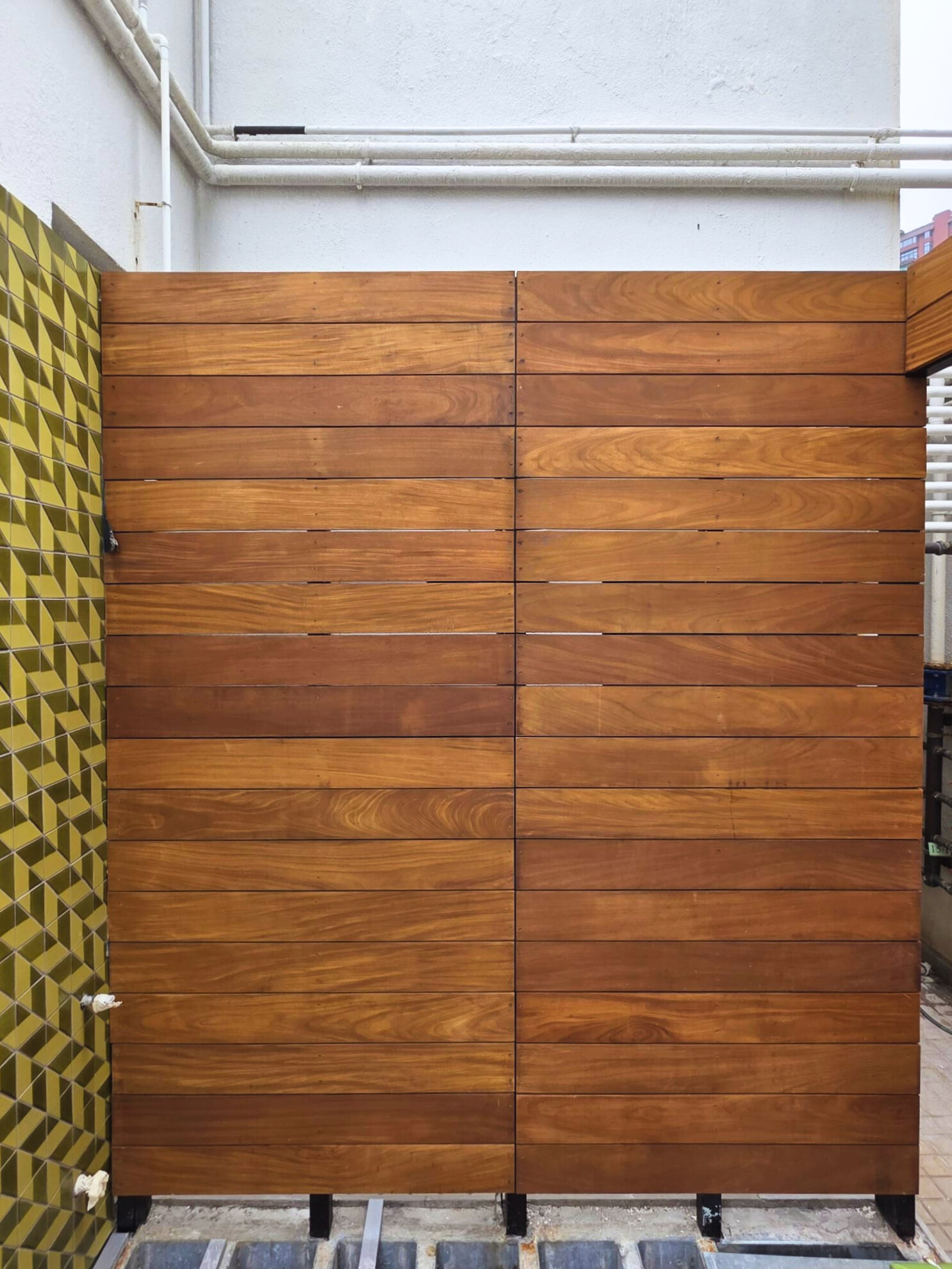 Premium Teak solid wood privacy fence installation for outdoor area, showcasing smooth timber panels and quality craftsmanship in Hong Kong architecture.