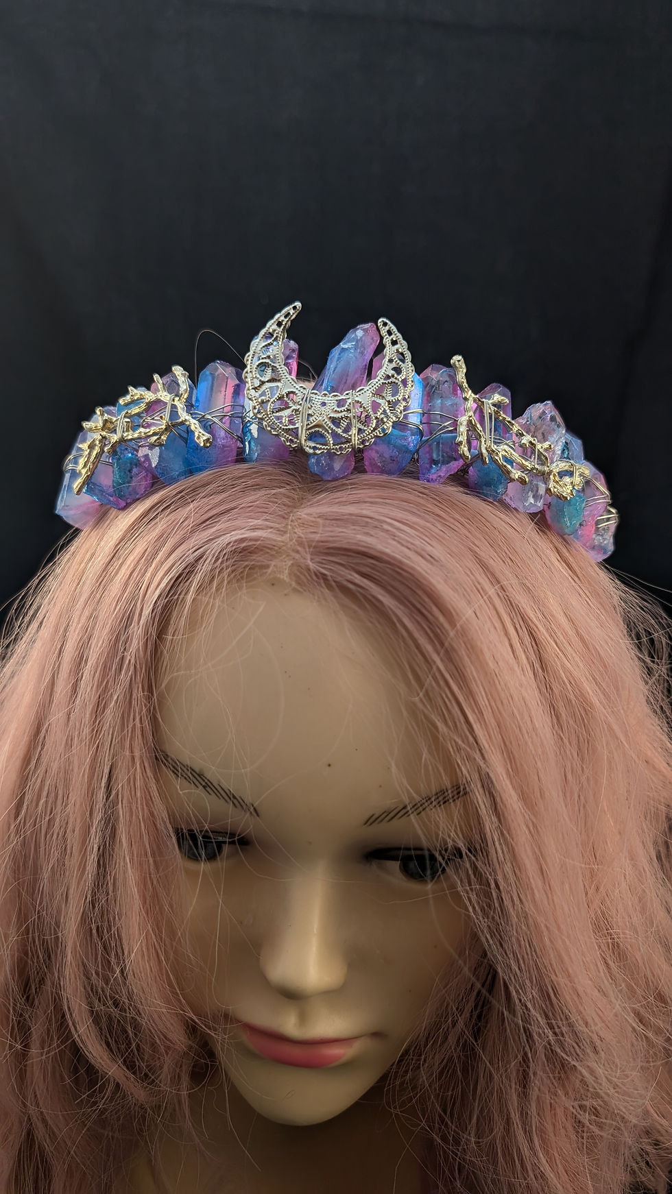 Mannequin mit rosa Haar trägt eine Krone aus blauen und rosa Kristallen.