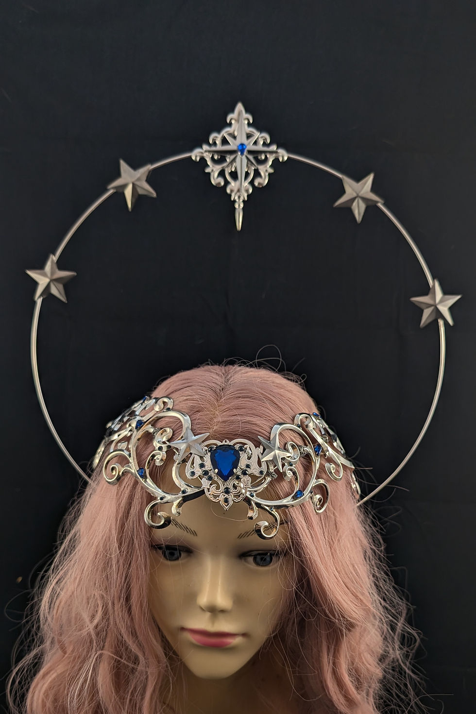 Silberne Tiara mit blauem Stein und Sternen-Heiligenschein auf Schaufensterpuppe.
