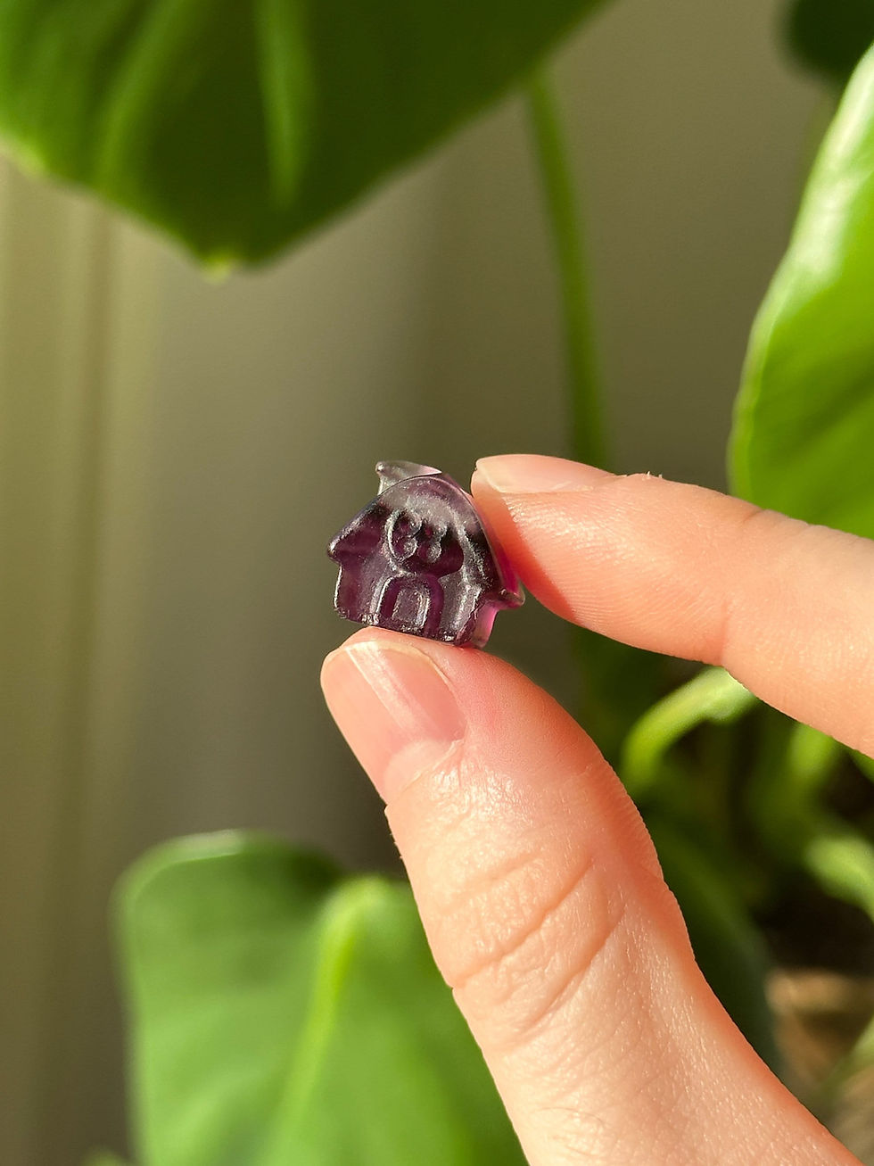 Rainbow fluorite house carving in hand