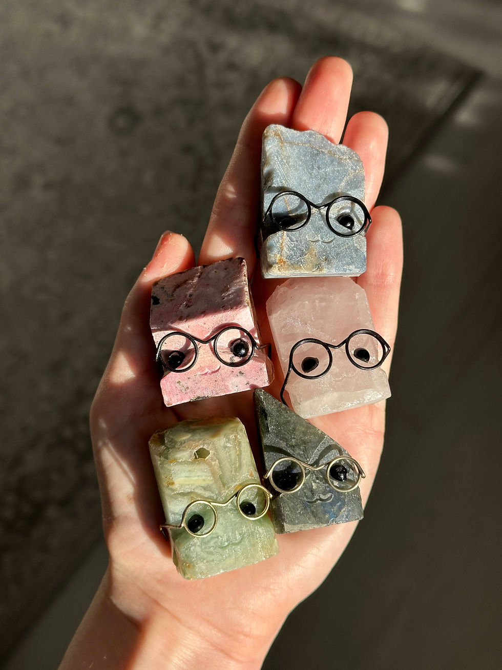Hand holding several crystal buddies with glasses