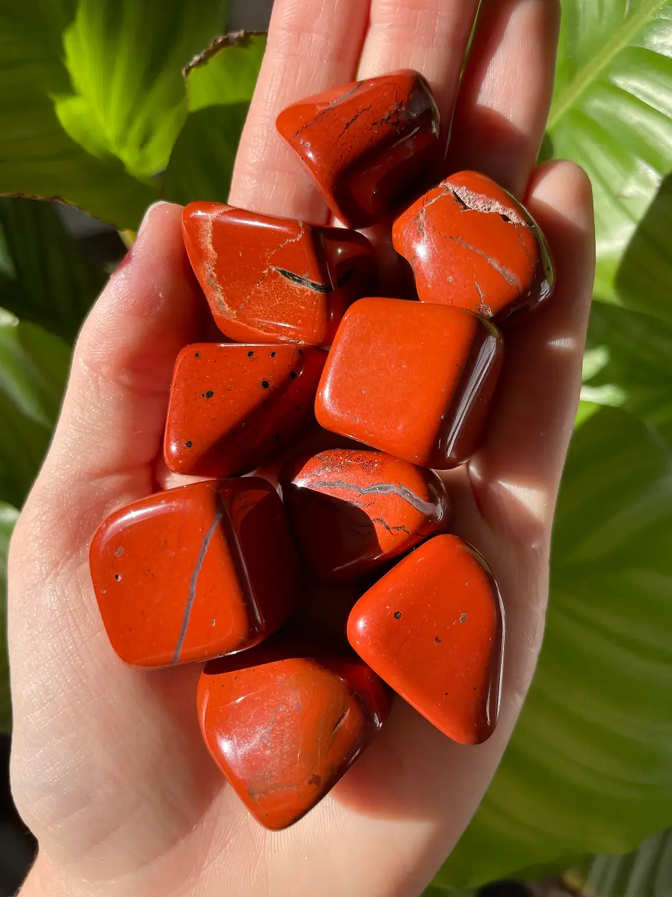 beautiful red jasper tumble stones upon a hand palm