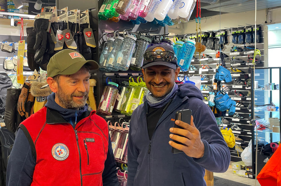 Two men smiling while shopping for outdoor gear.