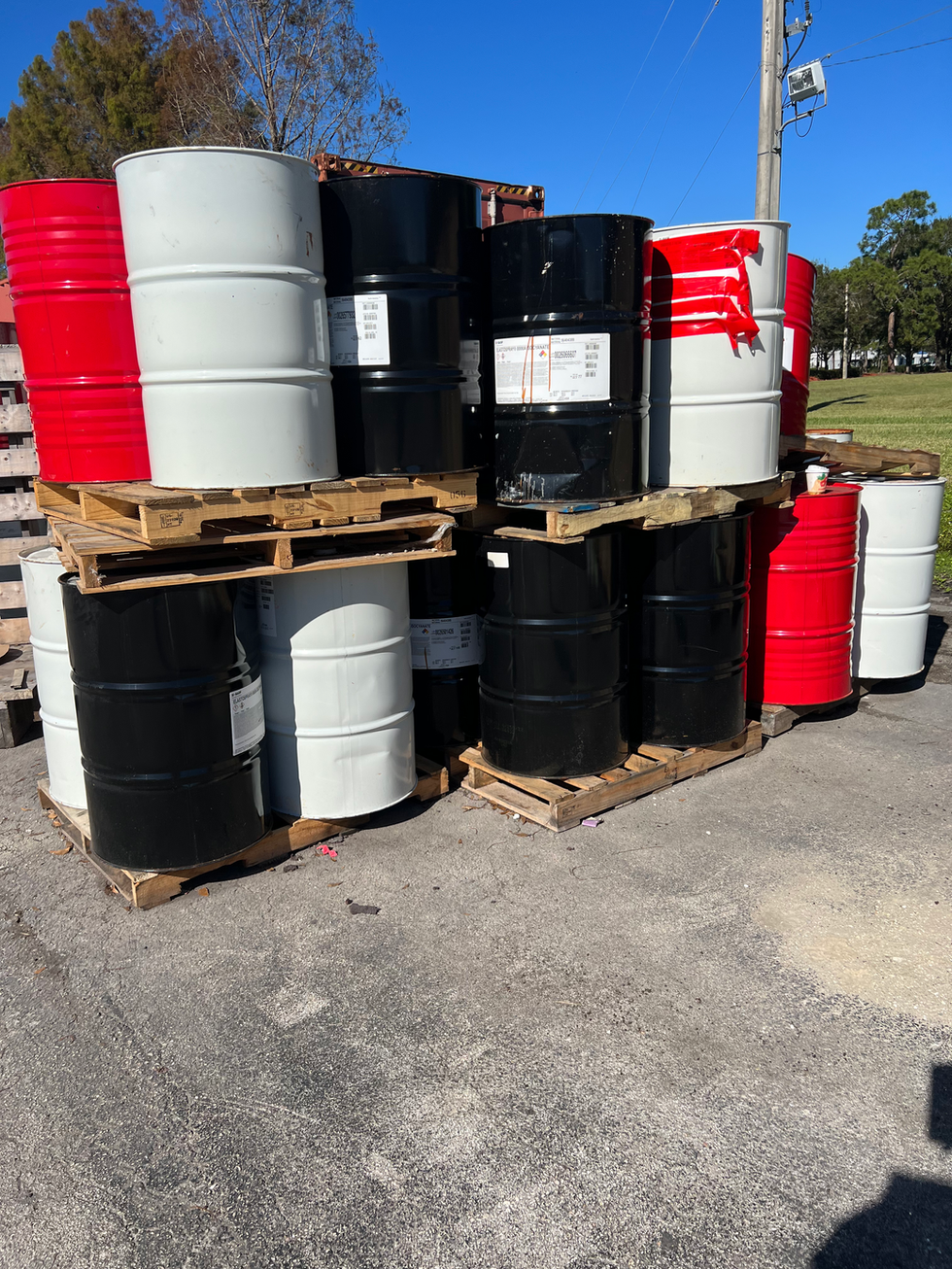 Stacked barrels on pallets. Recycled Industrial Pallets – Lightly Used & Heavy-Duty. Black, red, white barrels.