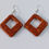 Thumbnail: Handmade orange glitter diamond shaped earrings on silver pl