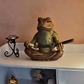 Frog statue holding braided sweetgrass