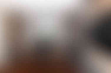 quarto com escrivaninha e parede de tijolinhos e tv