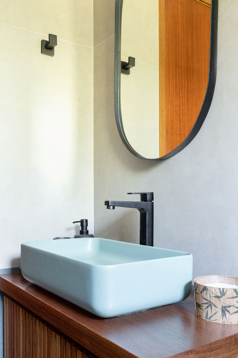 pia de banheiro em louça azul e espelho preto