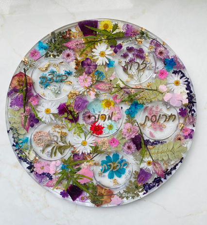 Colorful dried pressed flowers preserved in epoxy resin in a seder plate