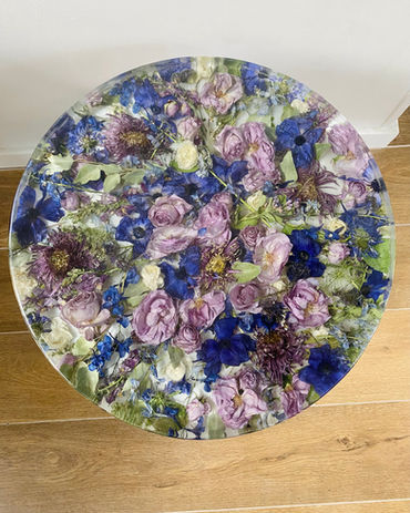 round table with preserved bridal bouquet flowers in purples and greens in epoxy resin