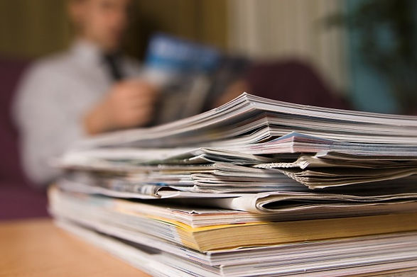 stack of publications with man in background reading_sm.jpg