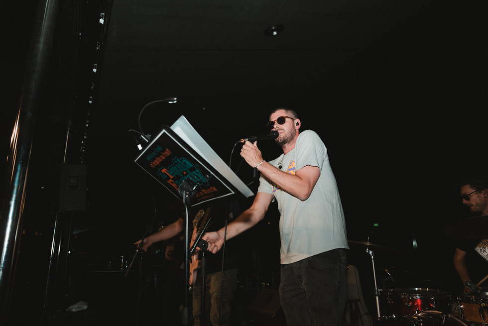 Frontaufnahme des Sängers mit Sonnenbrille beim Auftritt der Band.